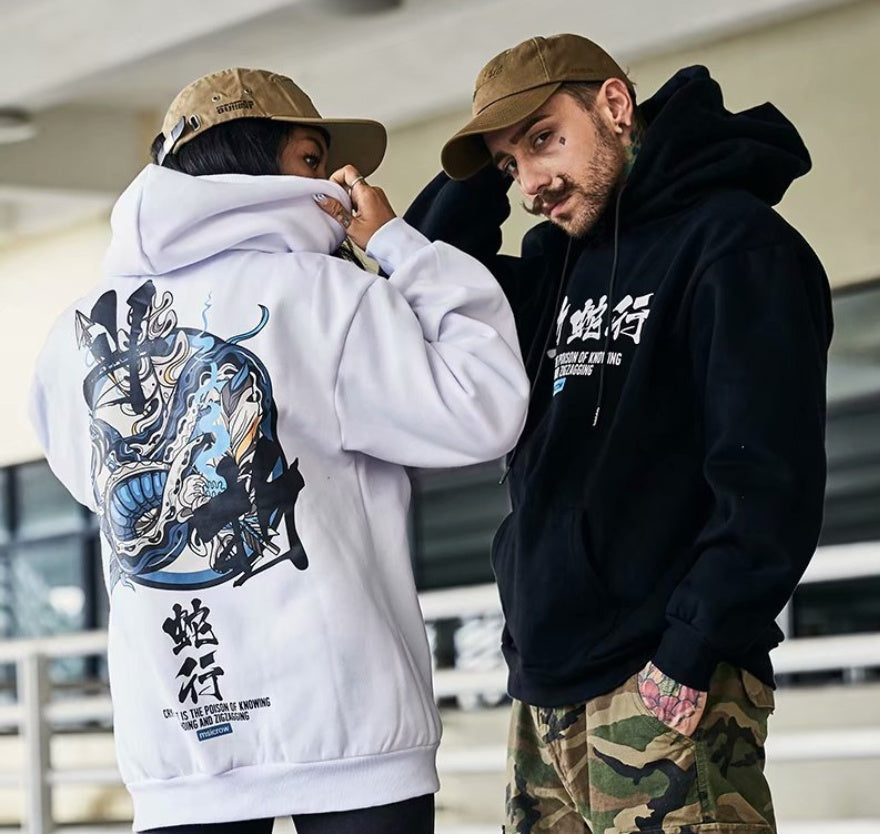 Two people wearing hoodies with visible branding and designs.
